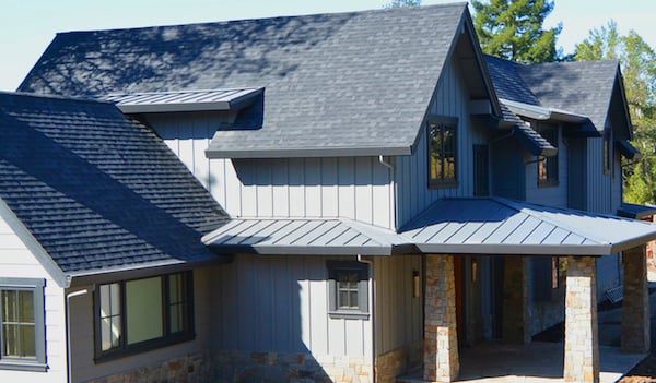 Metal and asphalt shingle roofing combination in dark grey. 