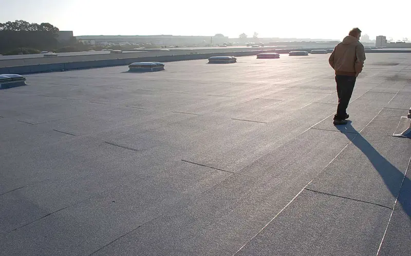 Roofer walks on built-up roof in San Francisco